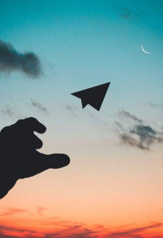 A hand throwing a paper plane